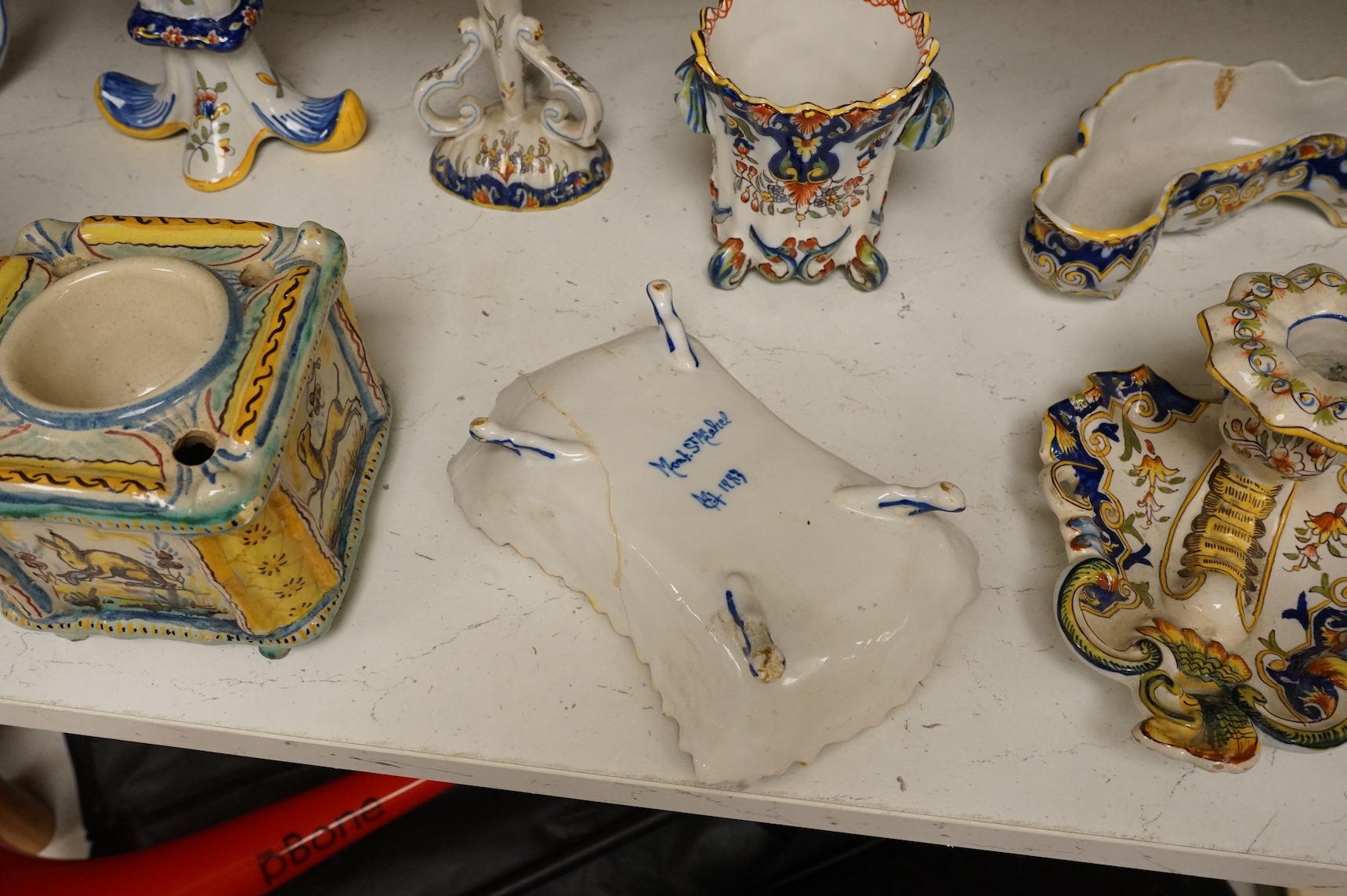 A group of French faience pottery to include spill vases, an ink well and dishes, largest 21cm high